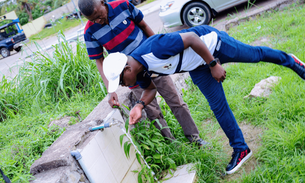 OVAF's General Manager with a Police Officer Tasting the Purity of the Water